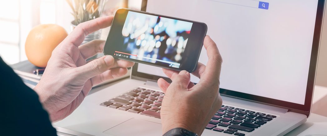 スマートフォンで動画を視聴しながらパソコン作業をする様子